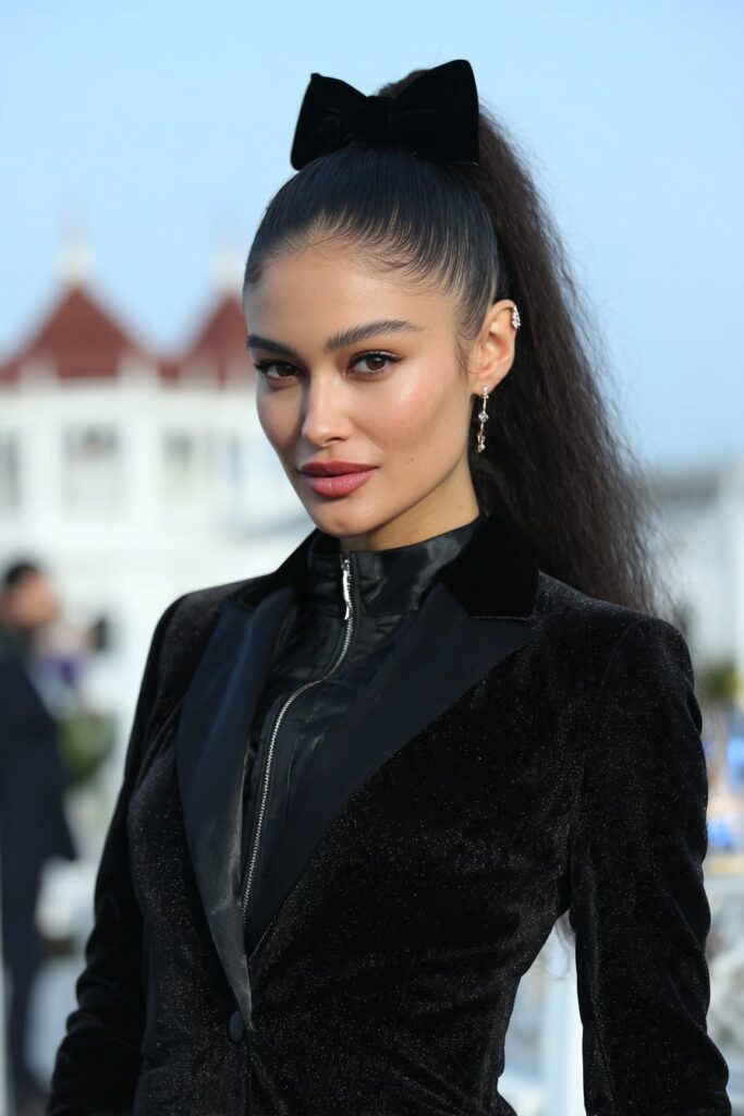 Half-up braided hairstyle decorated with a velvet bow for a festive feel