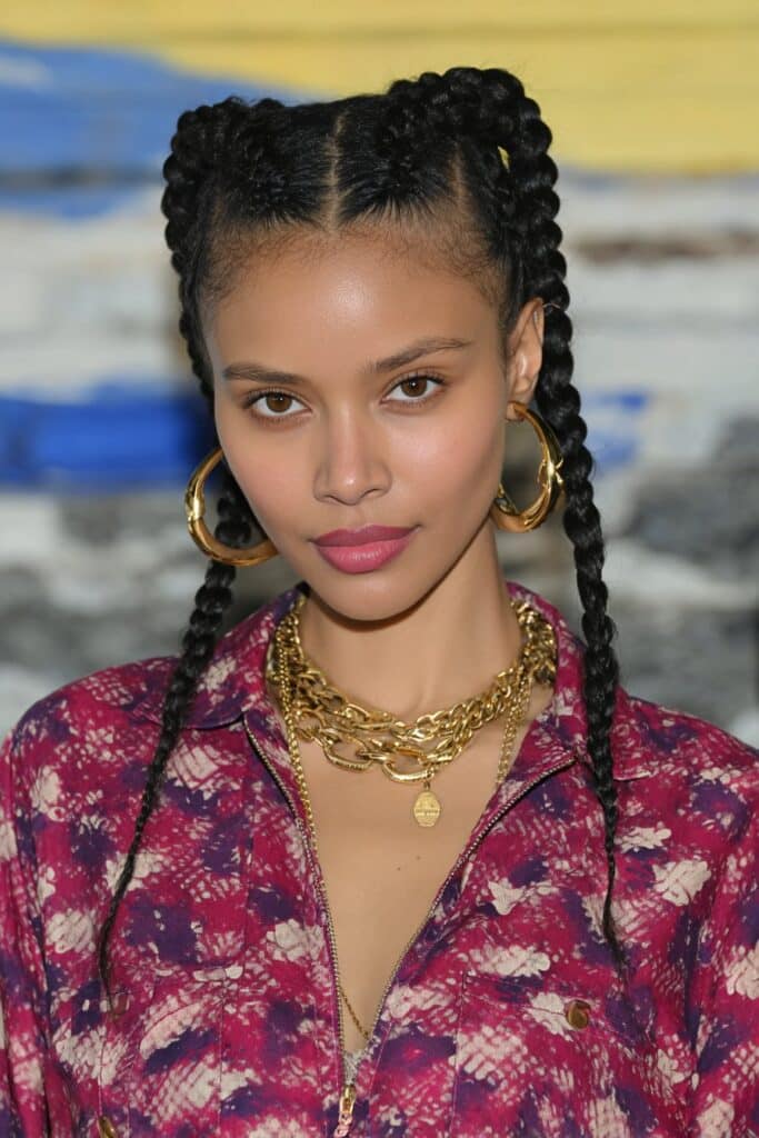 Woman styling half-up half-down knotless braids with curls