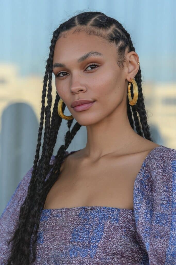 Low bun cornrows with curly ends for a soft, practical look