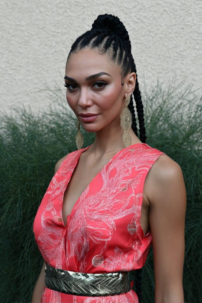 Side-Parted Knotless Braids with French Curls on a woman showing a defined side part