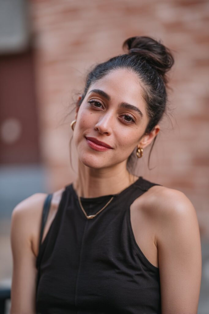 Intricate double fishtail bun for women over 60, in caramel brown, against a soft gray fabric backdrop.