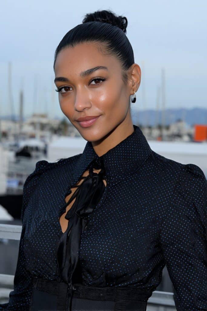 Sleek, slicked back bun on a woman with medium-length hair for a clean and sophisticated finish.