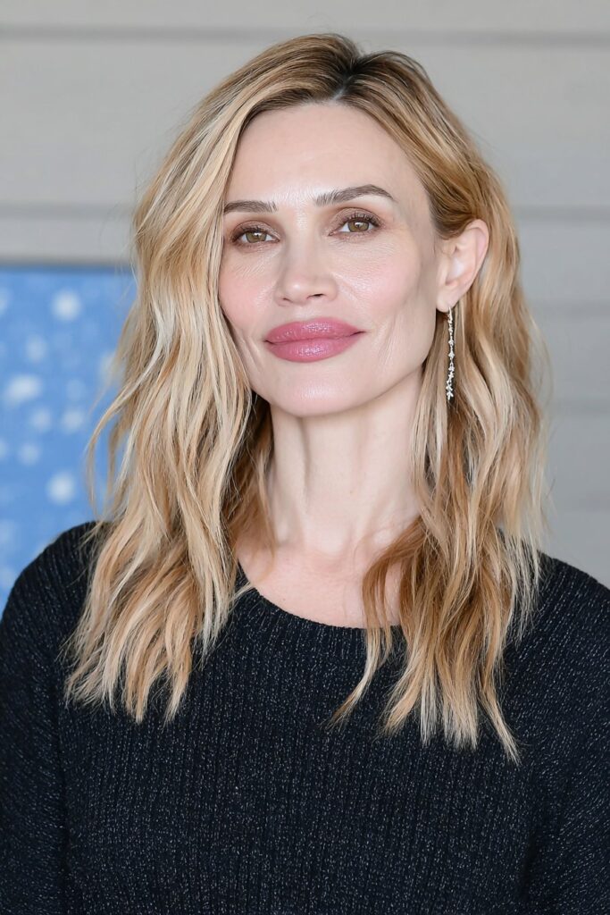 Soft beige blonde long shag for woman over 50 with subtle layers and natural texture.