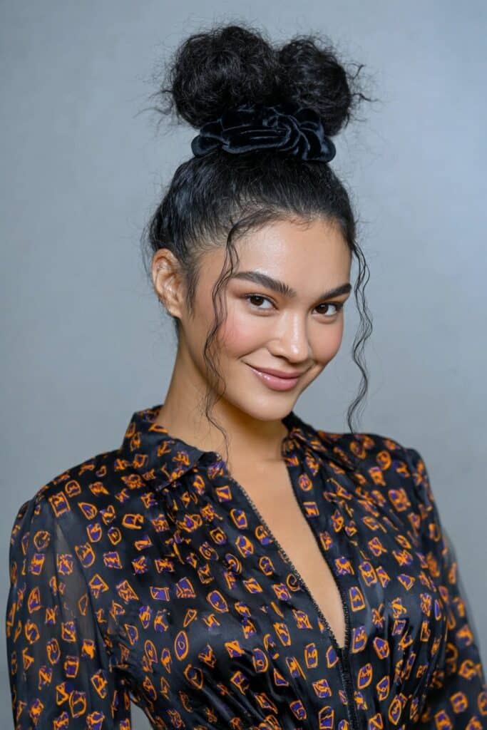 Low bun tied with a velvet bow on a woman’s medium hair, festive and graceful.
