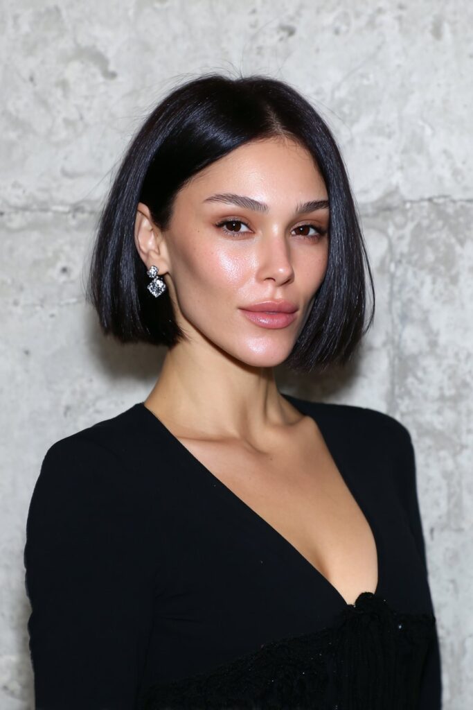 Woman with a voluminous bob hairstyle and side bangs.