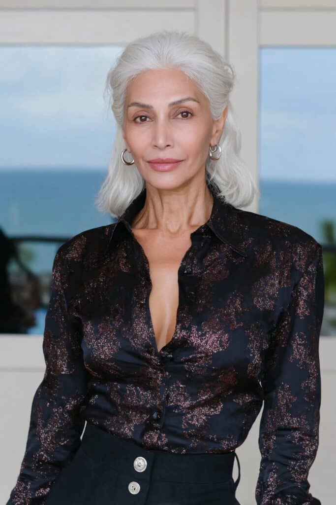 Natural 60-year-old woman with medium-length wavy butterfly haircut emphasizing her soft texture.