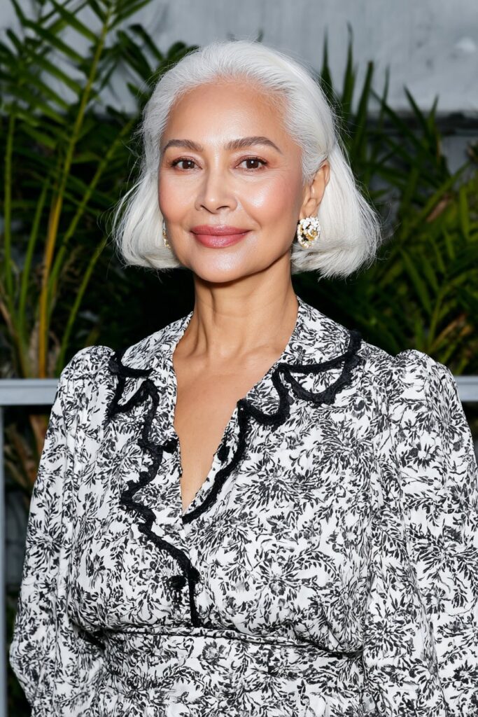 60-year-old woman with a rounded butterfly haircut that softens facial features and adds elegance.