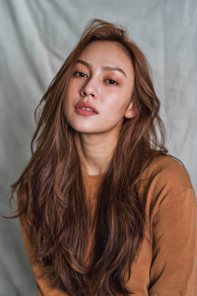 Warm medium brown hair with creamy butterscotch hues throughout for a soft, glowing warmth.