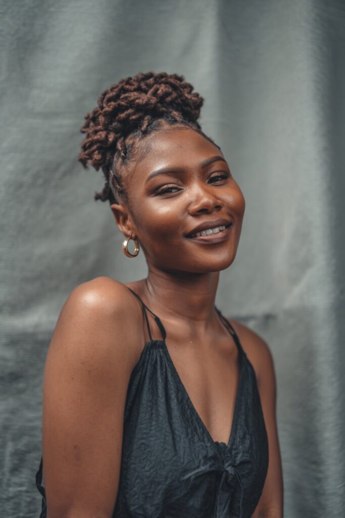 Scalp braids gathered upward into a bun or pinned style, finished with defined curls.