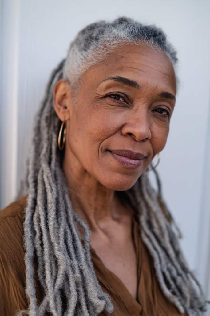 Long, neatly maintained gray dreadlocks styled with a smooth, polished finish for a refined look.