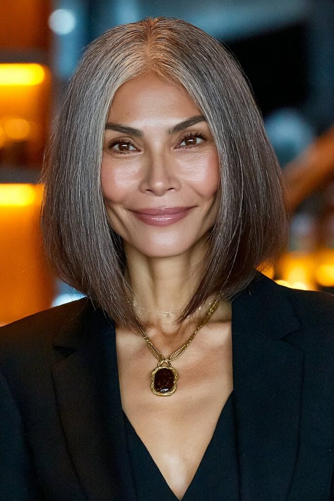 Mature woman age 60 with face-framing butterfly layers enhancing her natural features and providing lift.