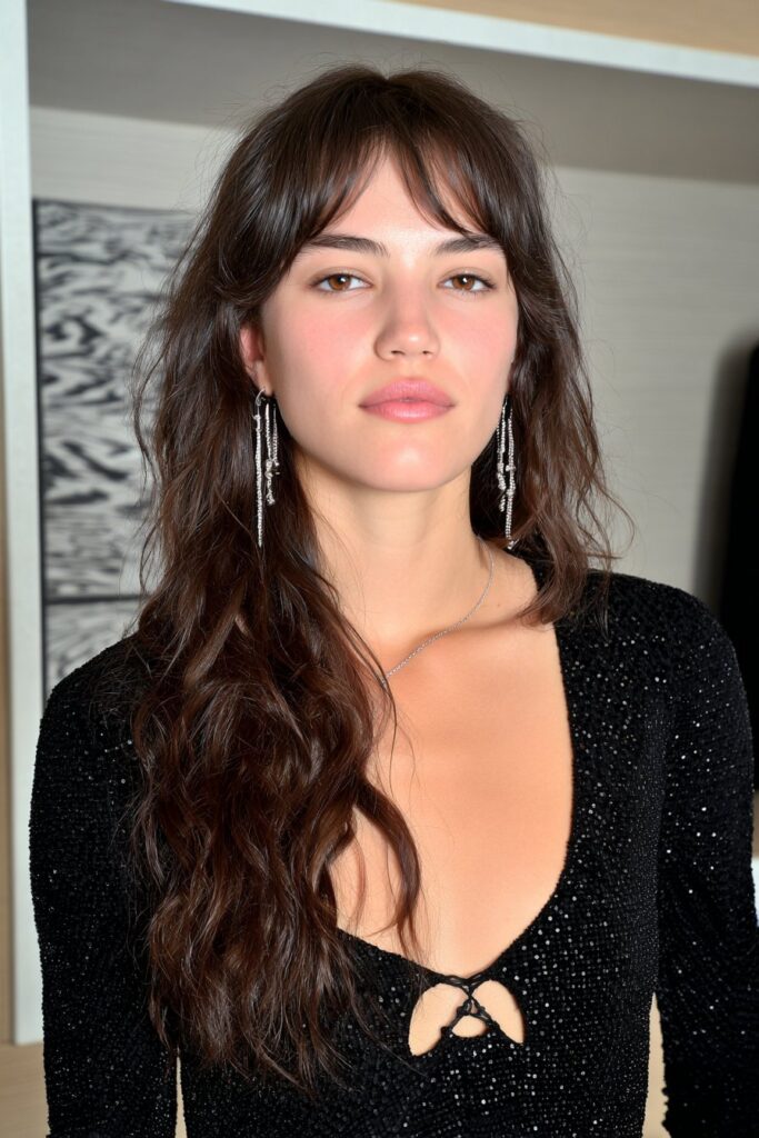 Woman with feathered layered medium hair and long bangs looking stylish