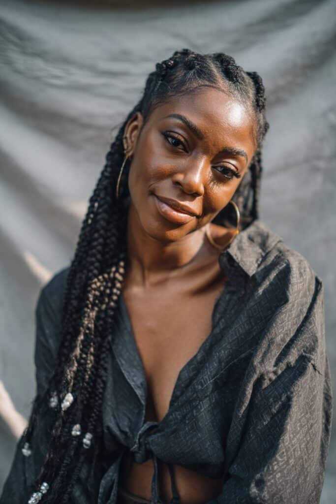 Cornrow-style braids featuring a central braid, side braids adorned with decorative beads and cuffs.