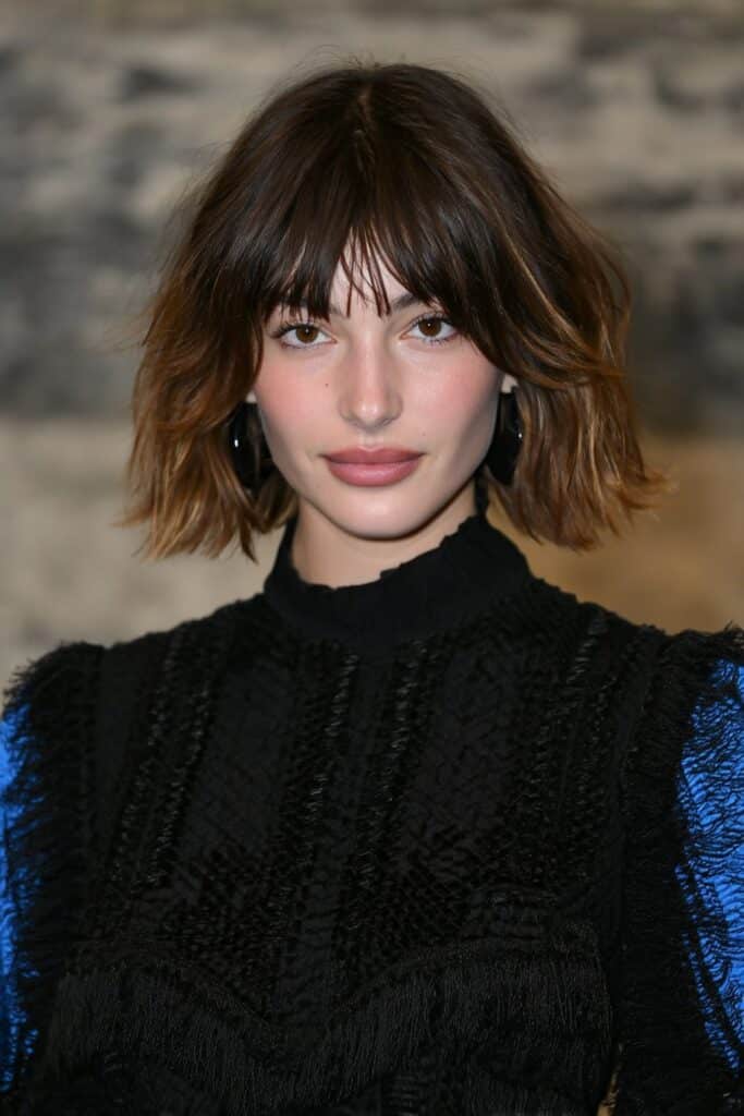 A woman with full fringe and layered butterfly haircut