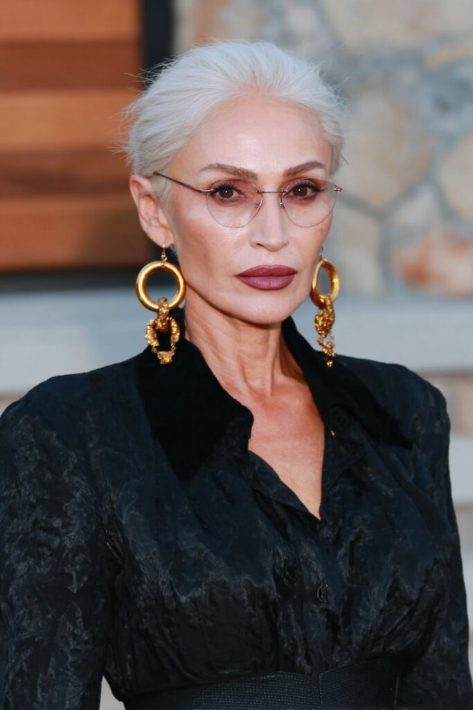 Woman over 60 with a chic layered pixie bob featuring stacked back layers and soft, face-framing pieces.