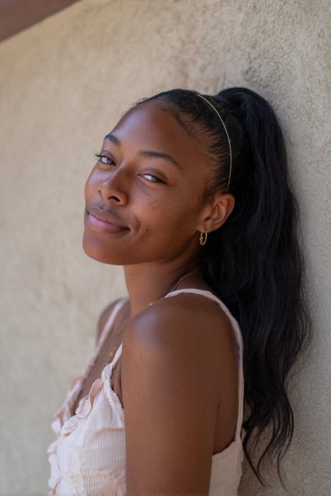 Hair gathered into a low, relaxed ponytail with soft volume and movement.