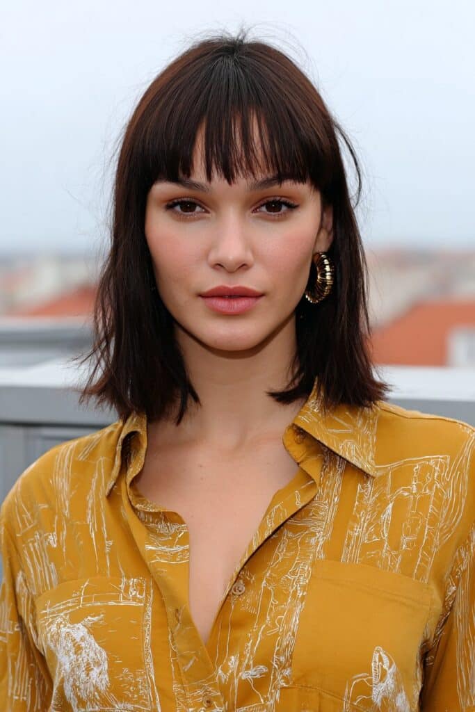 Woman with medium-length hair styled with side-swept bangs