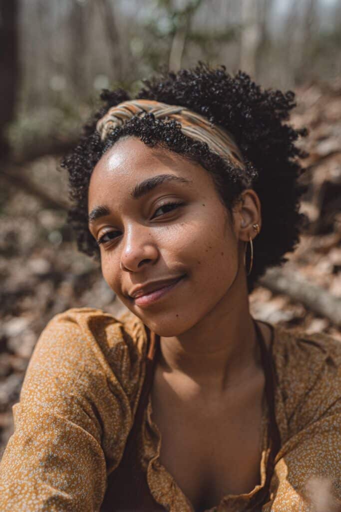 Short, defined curls styled with a headband for added detail and framing.