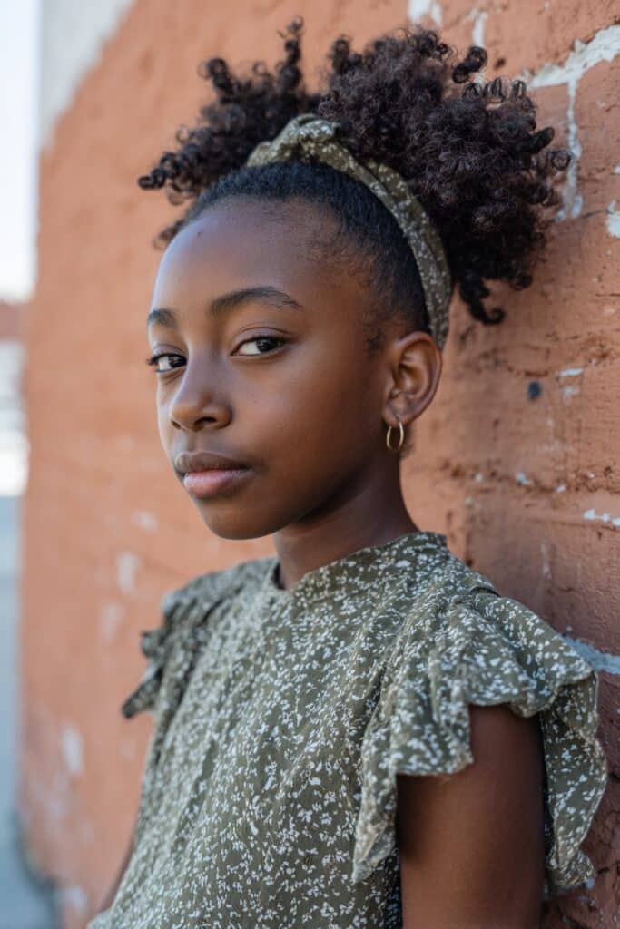 A voluminous curly afro brushed or shaped to sweep naturally to one side.