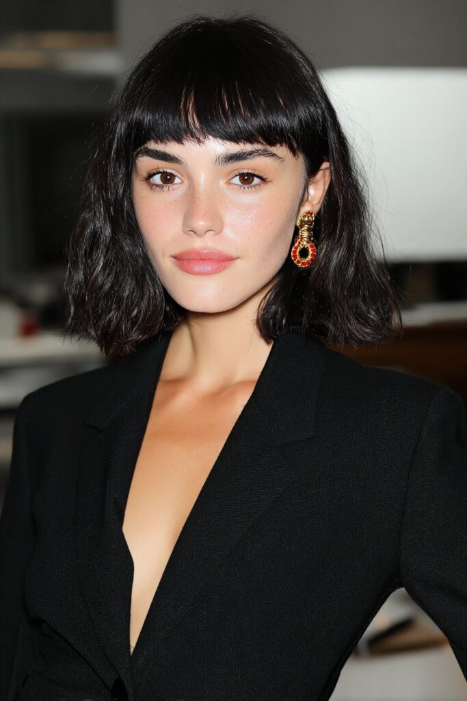 A woman with soft butterfly layers and wispy bangs