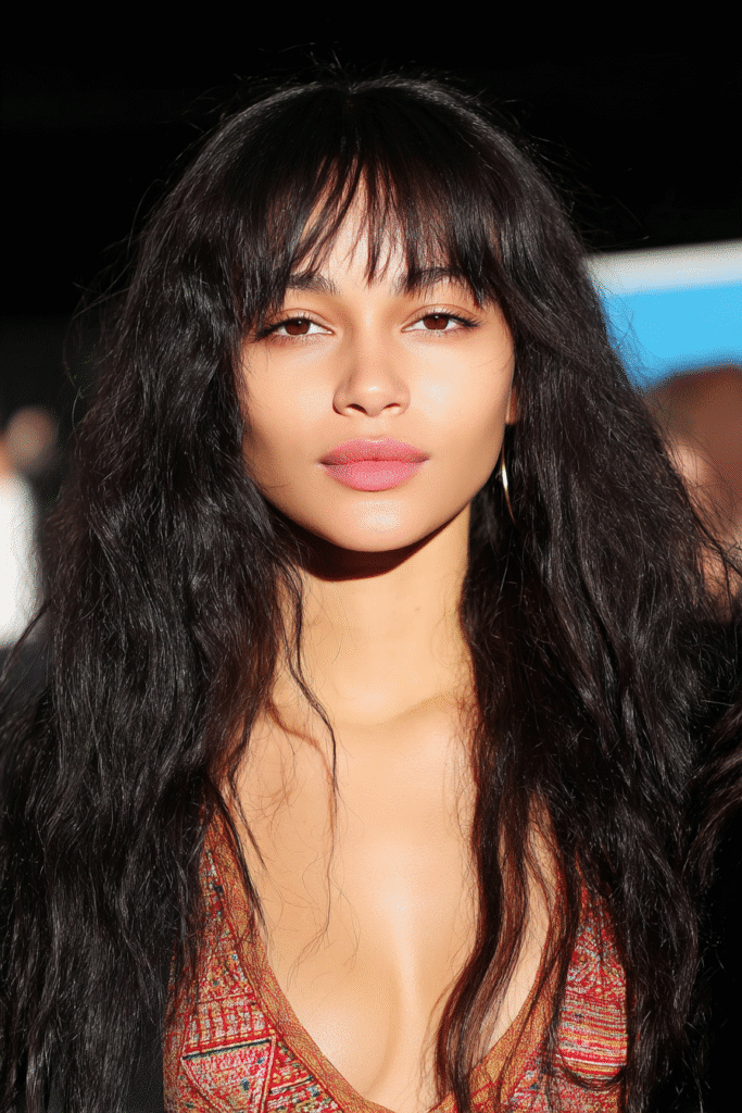 Woman with soft wavy hair and long bangs framing the face