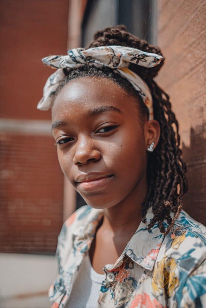 Stretched or blow-out textured hair accented with a headband for a soft, elongated look.