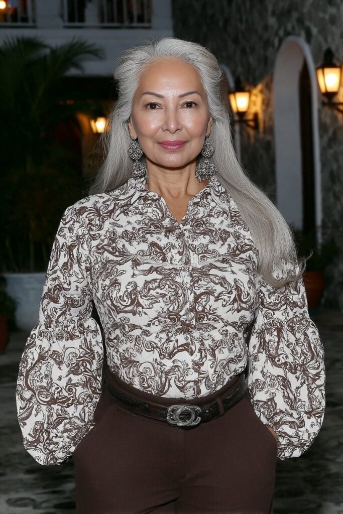 Fashionable 60-year-old woman with a textured butterfly cut featuring flicked ends for playful dimension.