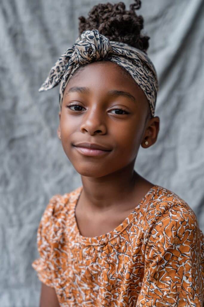 Hair pulled up into a smooth, high top-knot bun for a clean, elevated style.