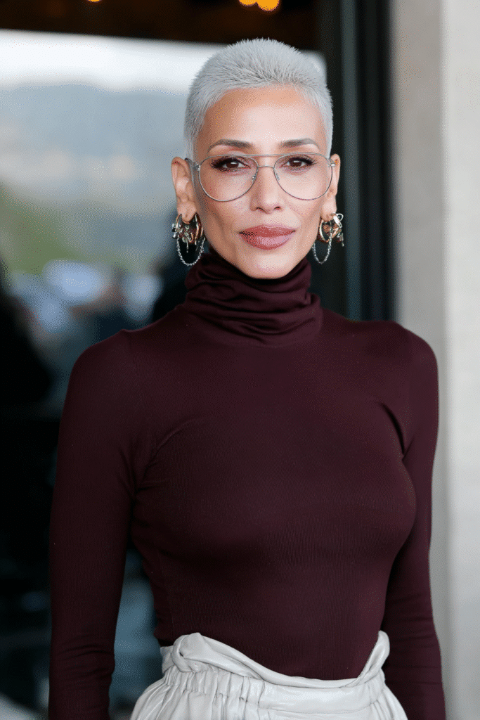 Confident woman over 60 with a bold undercut pixie featuring shaved sides and longer top layers.