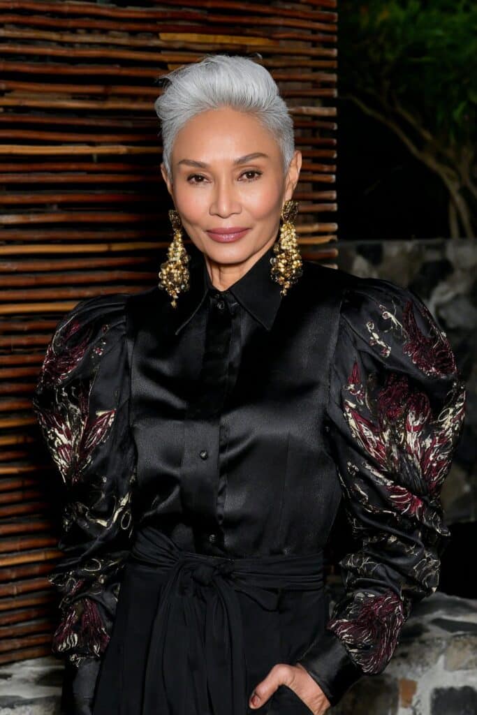 Stylish 60-year-old woman with a voluminous butterfly blowout hairstyle full of bounce and shine.