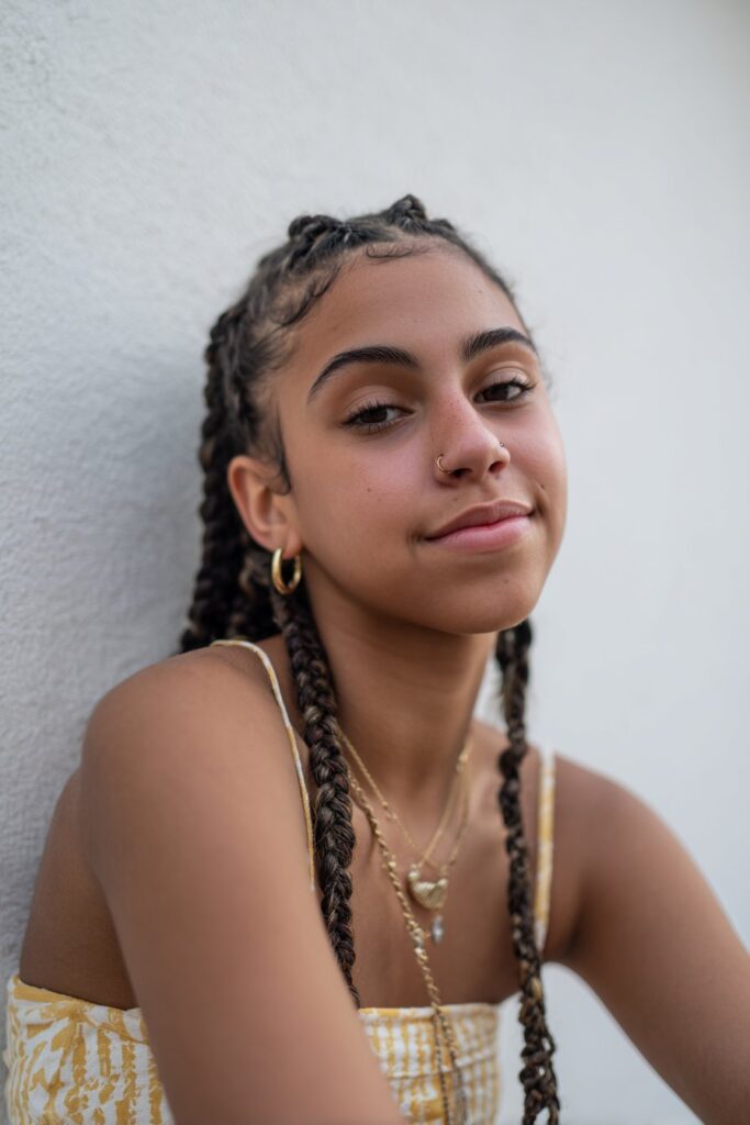 Front cornrows and back braids decorated with beads, cuffs, or charms for added detail.