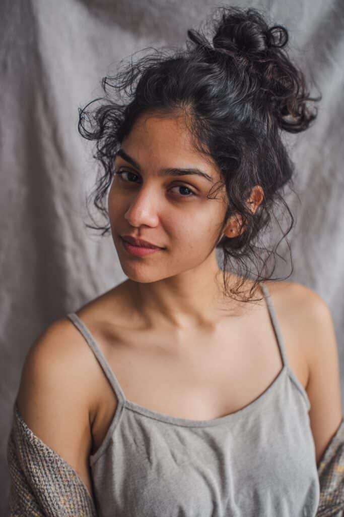 A low bun styled with loose, layered curls adding height and fullness around the crown.