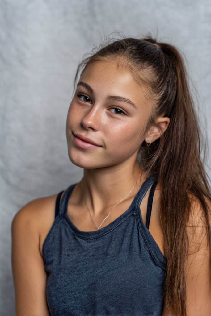 A sleek ponytail combined with soft, layered butterfly-style bangs.