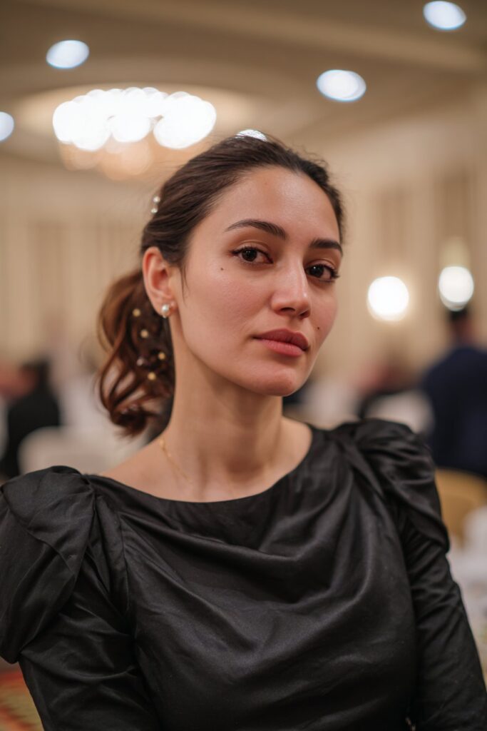 Bridesmaid side chignon hairstyle accented with pearl pins