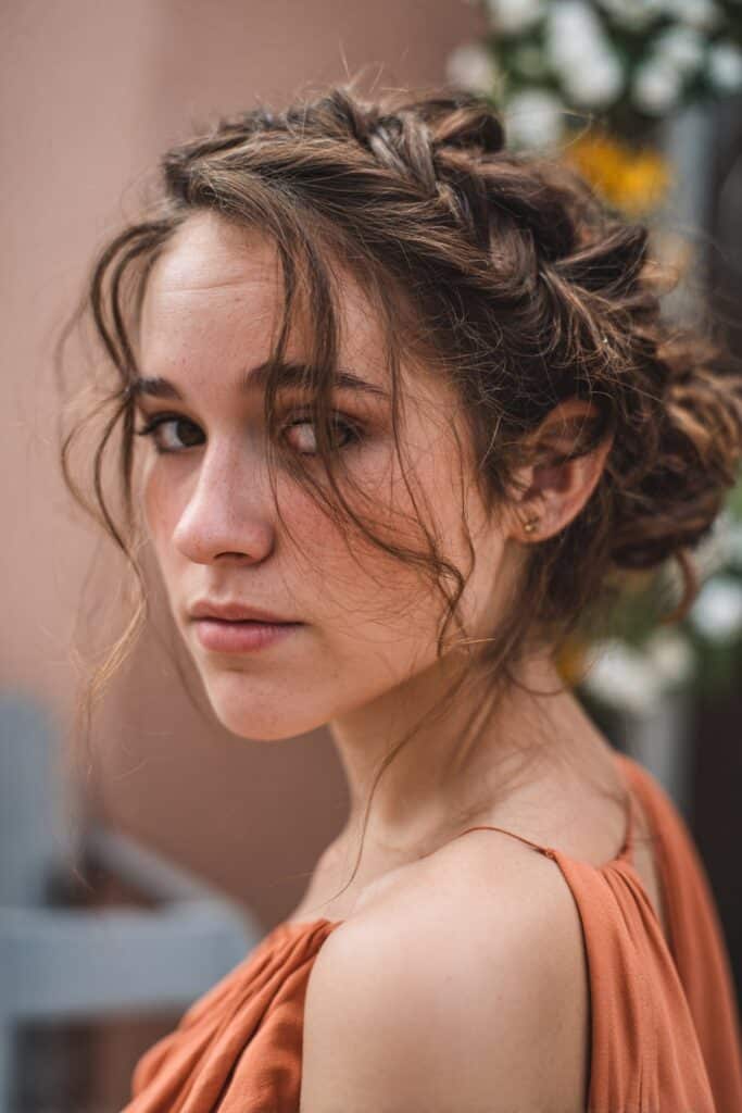 Messy braided updo with loose pieces for long fine hair prom