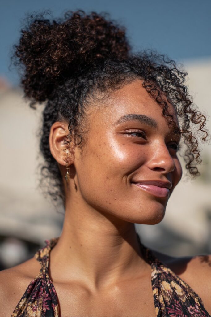 Curly bun updo with face-framing curls on Black hair