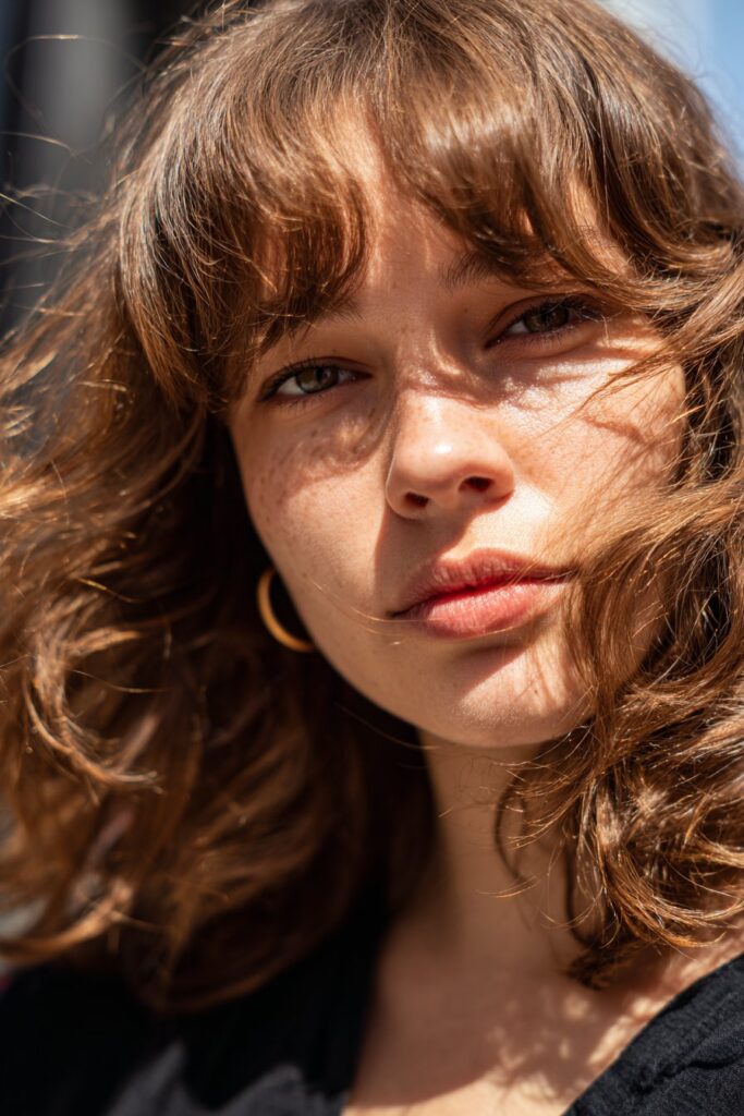 Wispy face framing long curtain bangs for heart shaped face