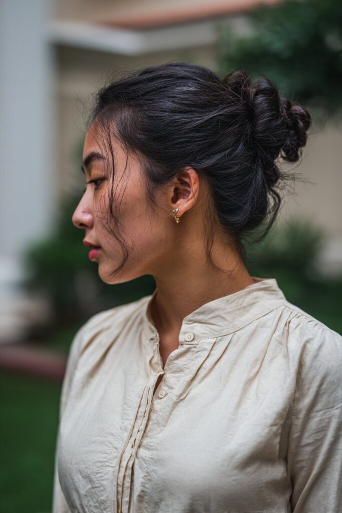 Low bun formal hairstyle with face framing pieces