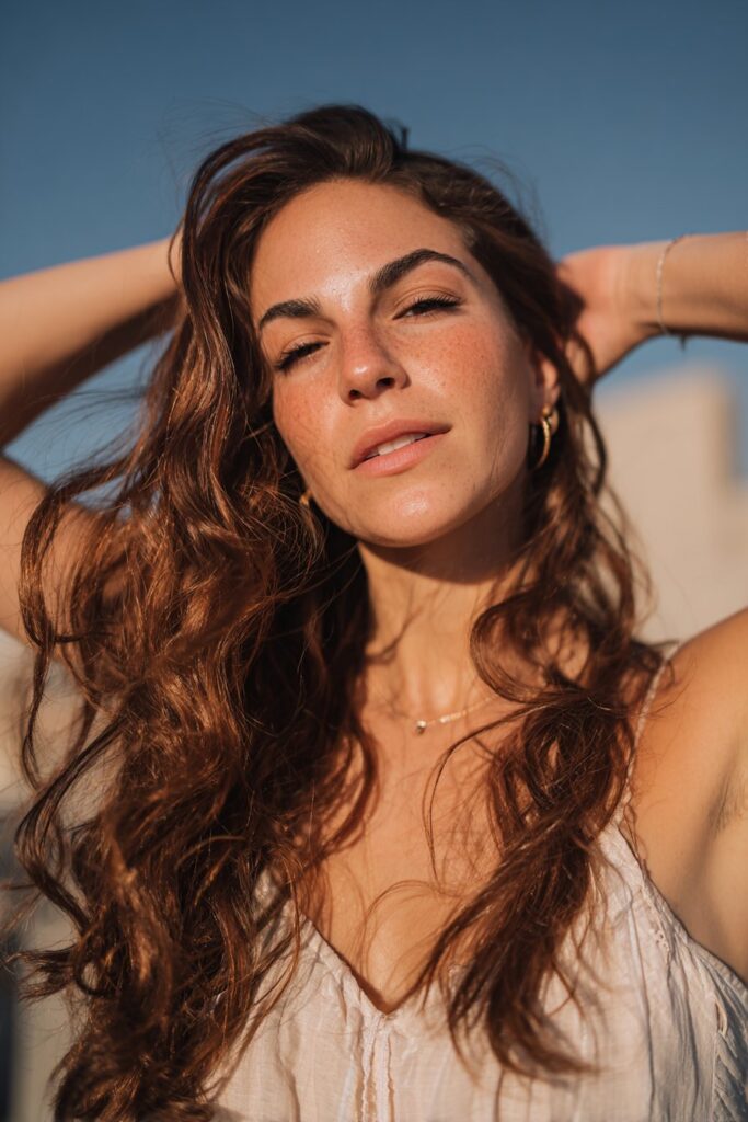 Sunkissed brunette hair with rose gold highlights and glossy finish