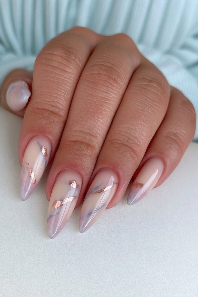 Gold foil marble stiletto nails with elegant artistic detail