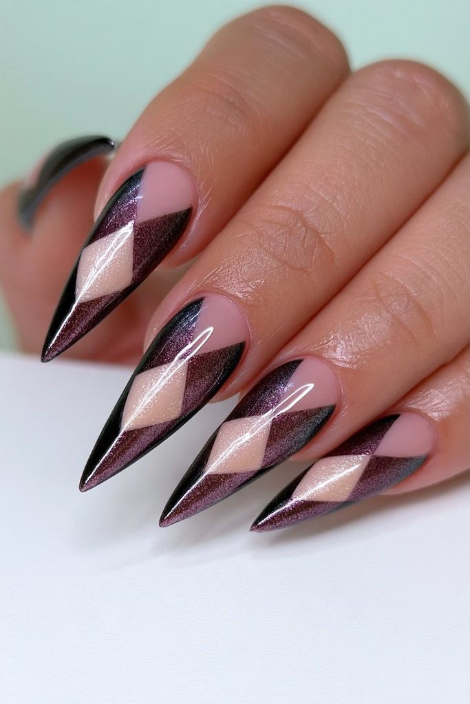 Harlequin noir stiletto nails with bold geometric dark pattern